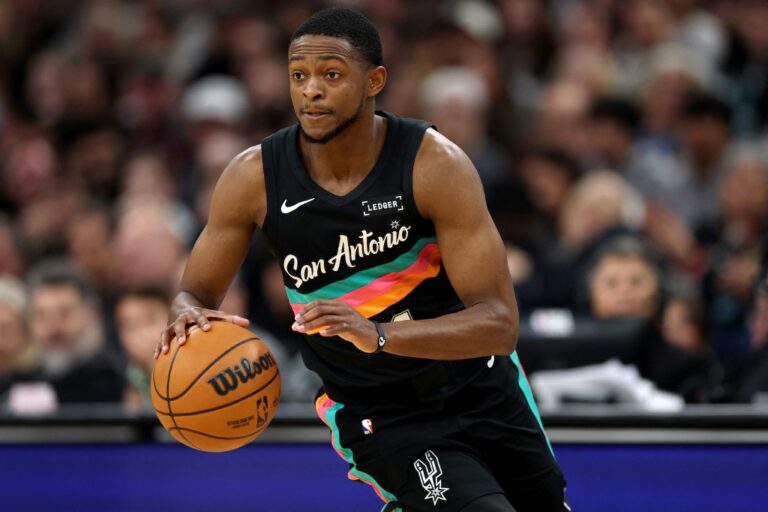 The cover for this NBA player props today article shows De'Aaron Fox #4 of the San Antonio Spurs in action during the first quarter of the game against the Cleveland Cavaliers.