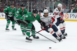 Lian Bichsel #6 of the Dallas Stars and Justin Sourdif #34 of the Washington Capitals compete for the puck.