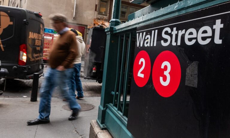 People walk by the New York Stock Exchange (NYSE) in New York City
