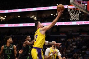 Luka Doncic #77 of the Los Angeles Lakers drives the ball around Karlo Matkovic #17 of the New Orleans Pelicans.