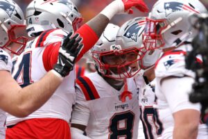 Drake Maye #10 and Stefon Diggs #8 of the New England Patriots celebrate with teammates during the second quarter in the AFC Championship Playoff game against the Denver Broncos.