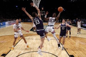 The cover for this college basketball picks today article shows Brandon Weatherspoon #23 of the Florida Atlantic Owls shoots against Luke Hunger #33 of the Northwestern Wildcats in the first round of the NCAA Men's Basketball Tournament