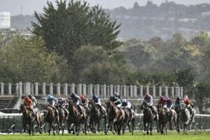 Jockeys race in heavy rainfall during a horse racing event.
