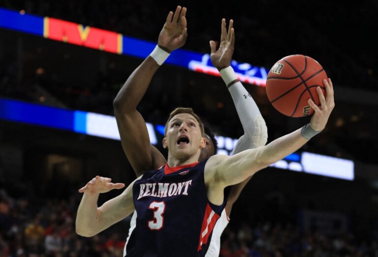 The cover for this college basketball picks today article shows Dylan Windler #3 of the Belmont Bruins taking a shot against Bruno Fernando #23 of the Maryland Terrapins in the second half during the first round of the 2019 NCAA Men's Basketball Tournament.