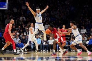 Ian Jackson #11 of the St. John's Red Storm looks to pass against Malik Messina-Moore #1 of the Xavier Musketeers.