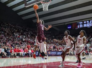The cover for this college basketball picks today article shows Marcus Hill #0 of the Texas A&M Aggies shooting a layup in the first half against the Alabama Crimson Tide.