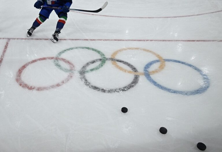 Olympic rings adorn the ice rink as players warm up prior to the an Ice Hockey match during the Milano Cortina 2026 Winter Olympic Games.