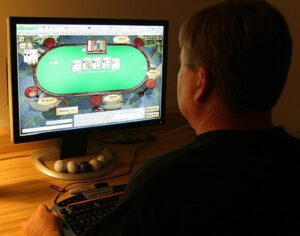 A man plays poker on his computer connected to an internet gaming site.